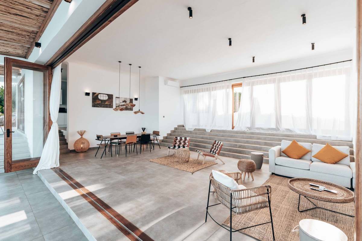 Bright open-plan living room with natural materials, woven furniture and African-style decor