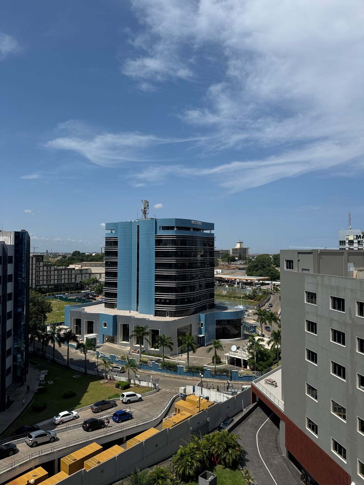 Modern office towers and palm-lined streets in central Accra