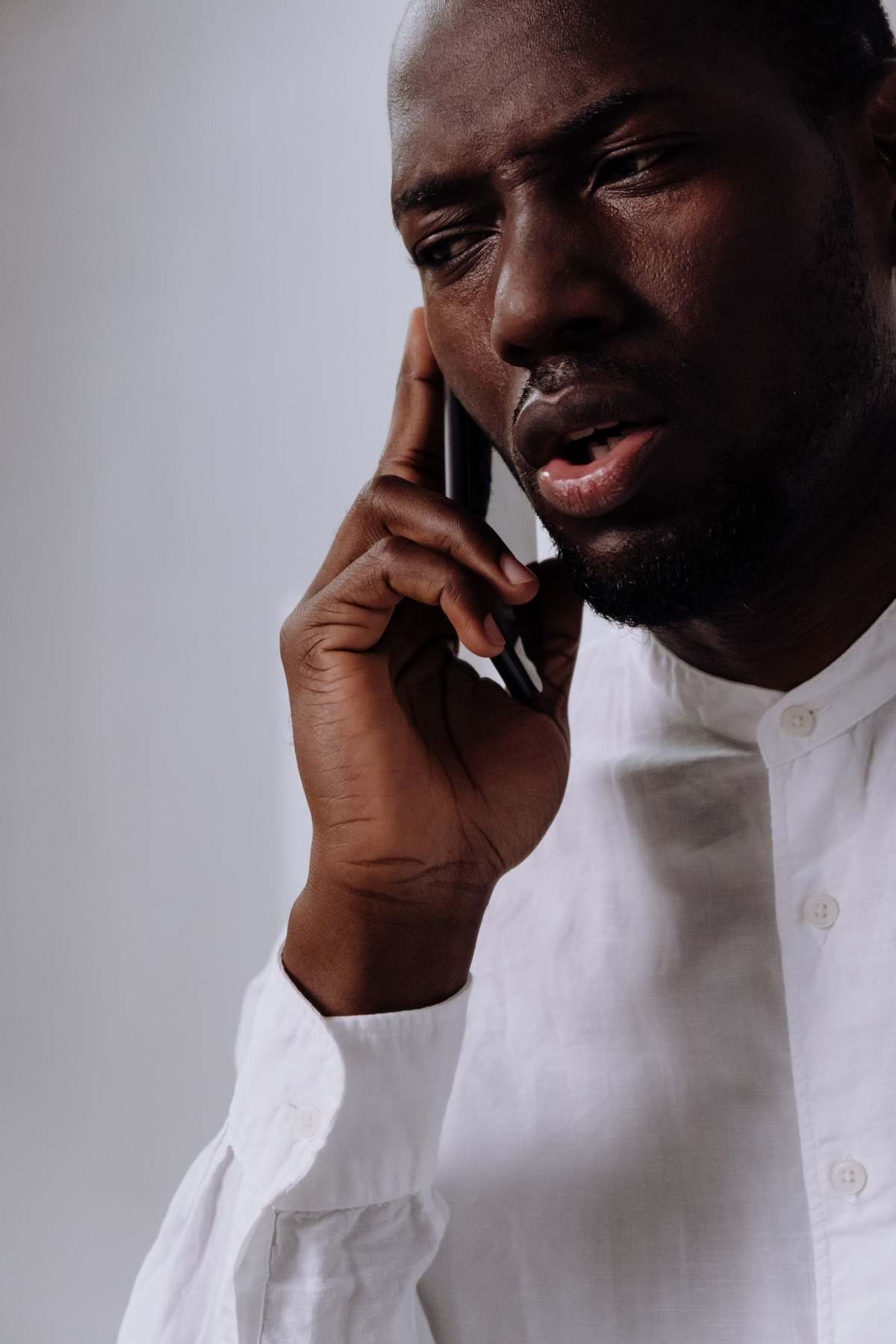 Close-up of a man in a white shirt speaking on his phone