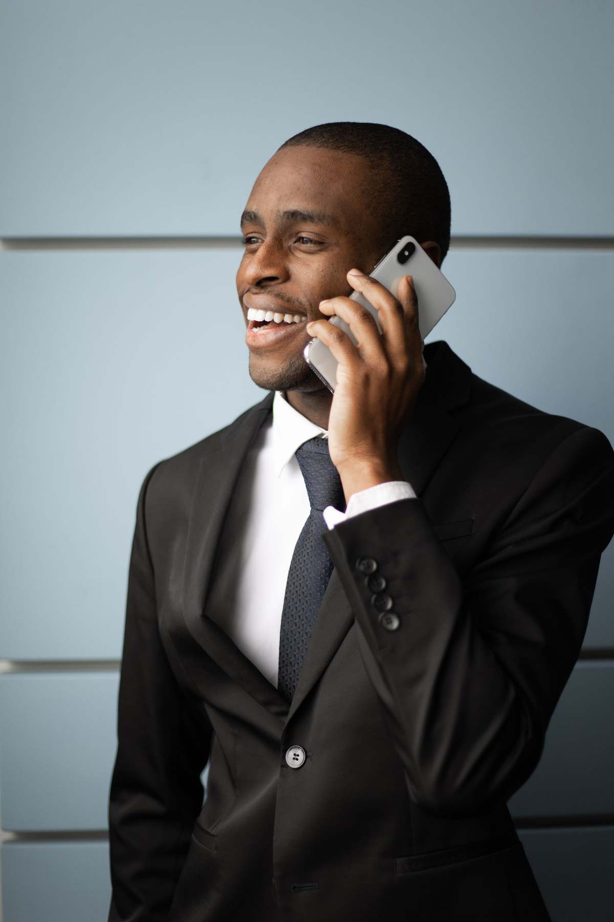 Smiling businessman in a dark suit taking a phone call