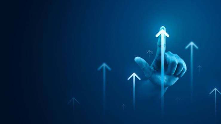 Main désignant une flèche lumineuse pointant vers le haut parmi d’autres flèches ascendantes, sur fond bleu foncé